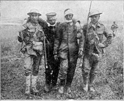 COMRADES AFTER THE BATTLE  Soldiers bringing in two wounded captives.  PHOTO BY CENTRAL PHOTO SERVICE. N.Y.