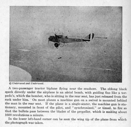 A two-passenger tractor biplane flying near the seashore.  The oblong black speck directly under the airplane is an aërial bomb, with guiding fins like a torpedo's, which the bomber, who is sitting in the rear seat, has just released from the rack under him. On most planes a machine gun on a swivel is mounted behind the man in the rear seat.  If the plane is a single-seater, the machine gun is stationary, mounted in front of the pilot, and "synchronized," or timed, to fire so that the bullets pass between the blades of the propeller, which is making about 1600 revolutions a minute.  In the lower left-hand corner can be seen the wing tip of the plane from which the photograph was taken.