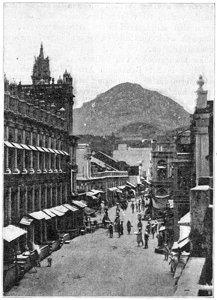 Hoofdstraat van Junagadh met den Girnar.