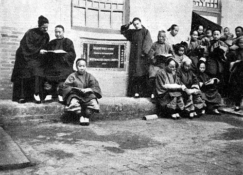 WOMEN'S BIBLE SCHOOL. Mrs. Hsi on the left, sharing a book with Miss French. Mrs. Liang on the right, sitting at Miss Cable's left. To face page 160.