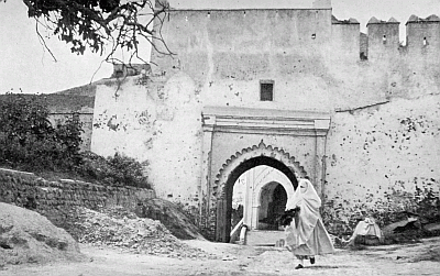 A VEILED FIGURE OUTSIDE THE GATE.