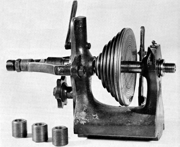 Figure 16.—Headstock of a German instrument-maker’s lathe, typical of the mid-19th century, showing the traverse spindle, interchangeable lead screws, and semicircumferential nut containing several leads. The nut may be brought into engagement by the lever at top rear of the headstock. This releases the end thrust control on the spindle simultaneously with engagement of the nut. (Smithsonian photo 49839.)