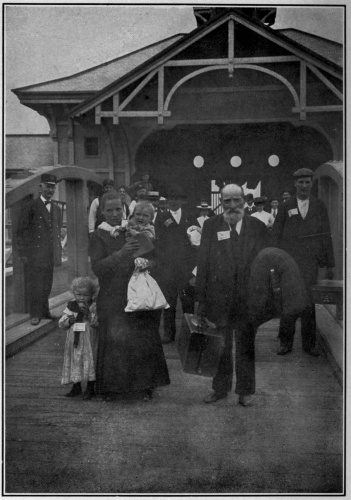 From stereograph copyright—1904, by Underwood & Underwood, N. Y. AT THE GATE  With tickets fastened to coats and dresses, the immigrants pass out through the gate to enter into their new inheritance, and become our fellow citizens.