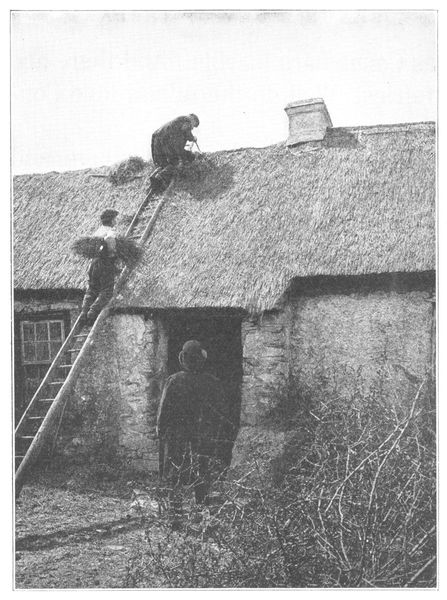 IRISH FARMER AND HIS SON PATCHING THE ROOF OF THEIR OLD STONE HOUSE