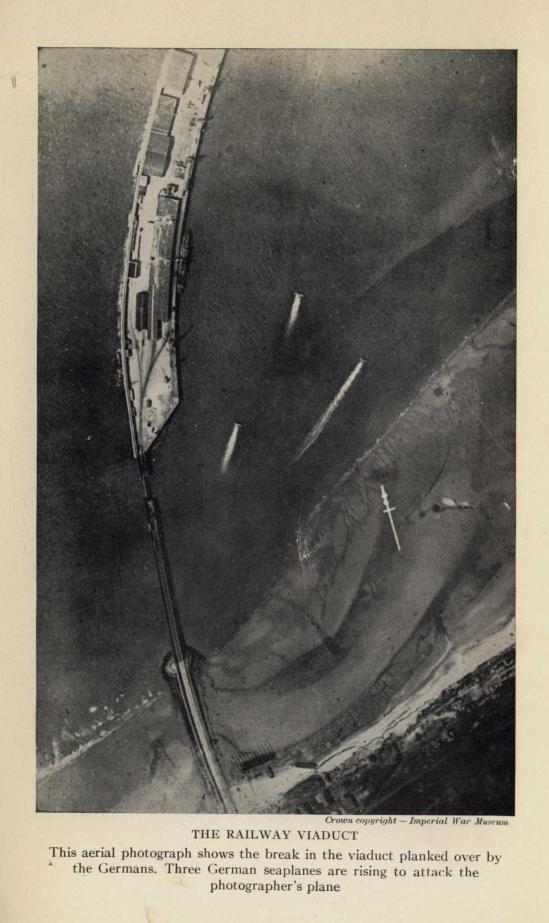 THE RAILWAY VIADUCT. This aerial photograph shows the break in the viaduct planked over by the Germans.  Three German seaplanes are rising to attack the photographer's plane