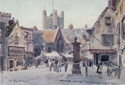 PEASHILL  The Chancel of St. Edward’s Church is seen behind the stalls in the roadway, and the Tower of Great St. Mary’s in the distance. On the right is the Old Bell Inn and the old town pump is in the foreground.