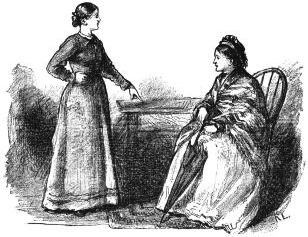younger woman standing in front of older seated woman