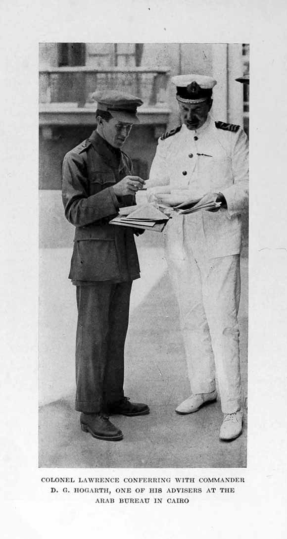 Photograph: COLONEL LAWRENCE CONFERRING WITH COMMANDER     D. G. HOGARTH, ONE OF HIS ADVISERS AT THE ARAB BUREAU IN CAIRO