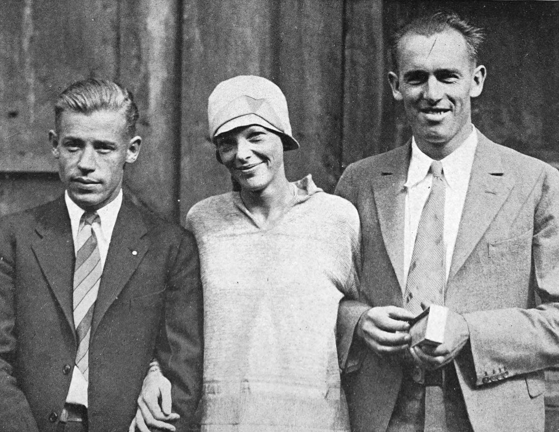 Photo medium shot of Stultz, Earhart, and Gordon with                 arms interlinked
