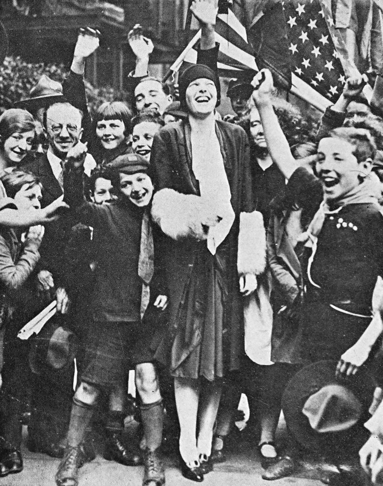 Photo full outdoor shot of smiling Earhart in a crowd of cheering children