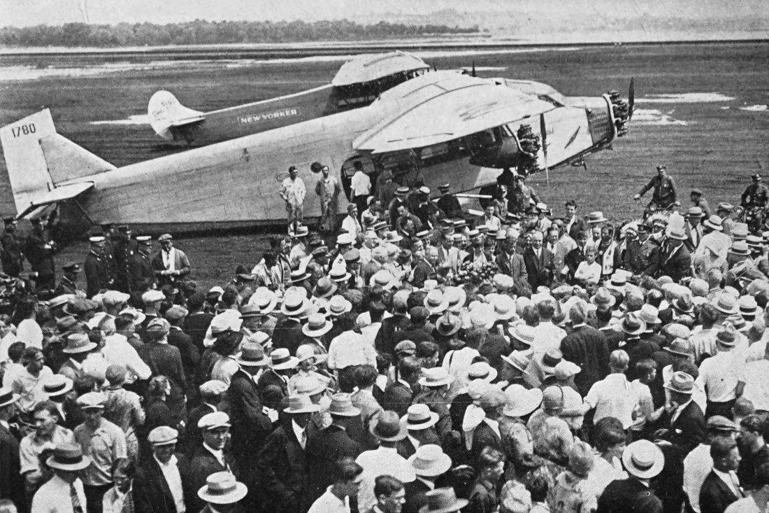 Photo wide outdoor shot of Friendship airplane on airfield with a crowd of people