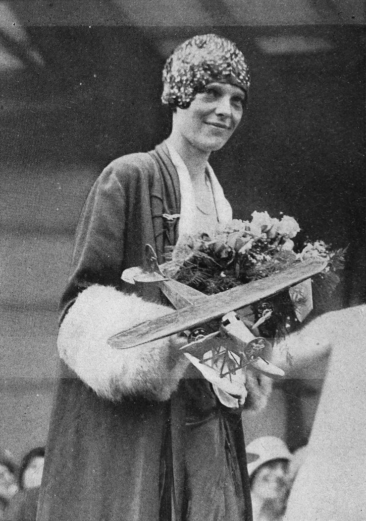 Photo medium shot of Earhart holding flowers and a model airplane