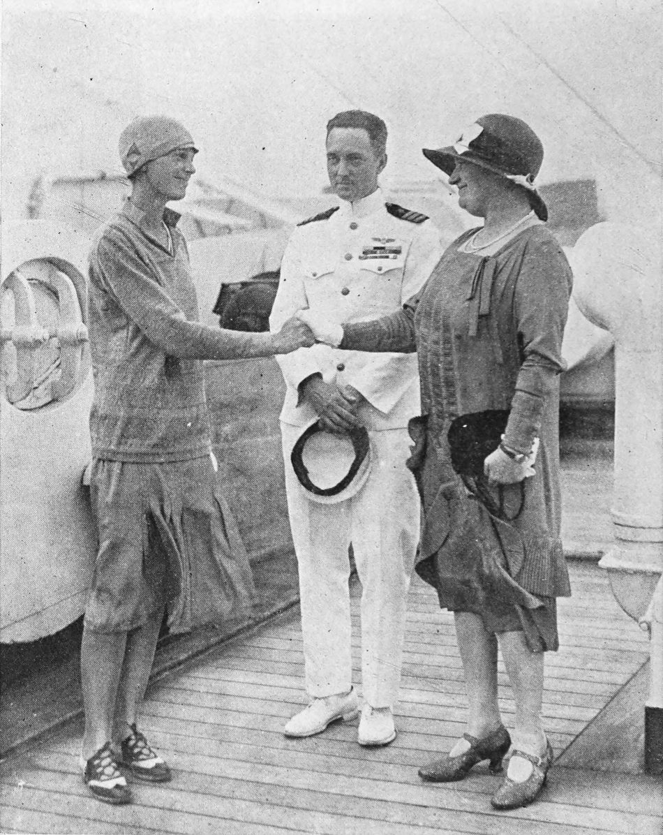 Photo full shot of Earhart shaking hands with Mrs. Guest as Commander Byrd looks on
