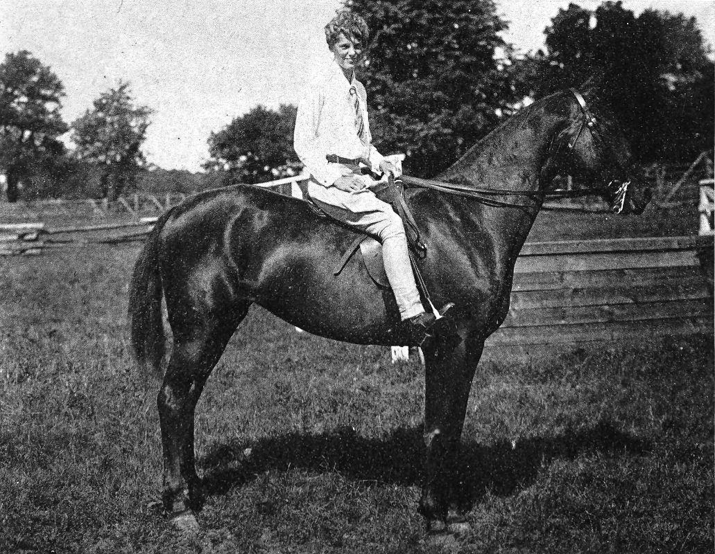 Photo wide profile shot of Earhart on a black horse