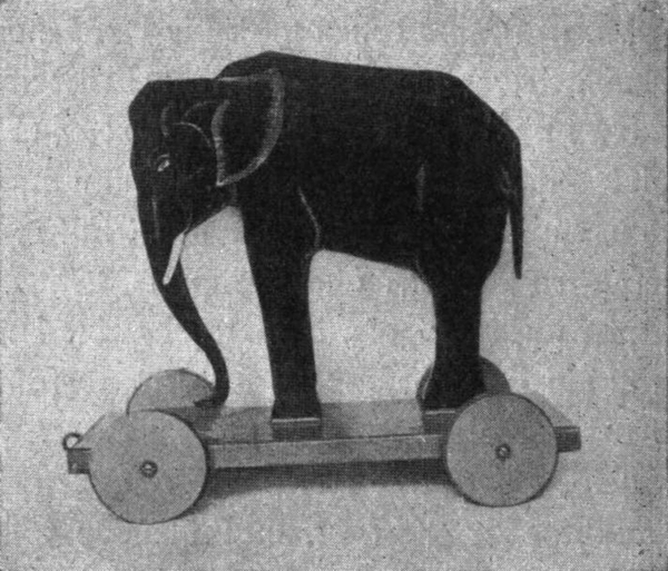 Elefant aus Holz, auf einen   kleinen Wagen montiert