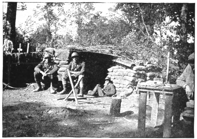Uniformed men sitting around a camp.