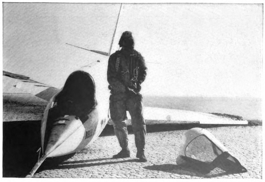 A man standing next to a sleek plane on the ground
