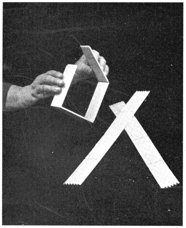 Hands shown bending wooden frame to form a small box.