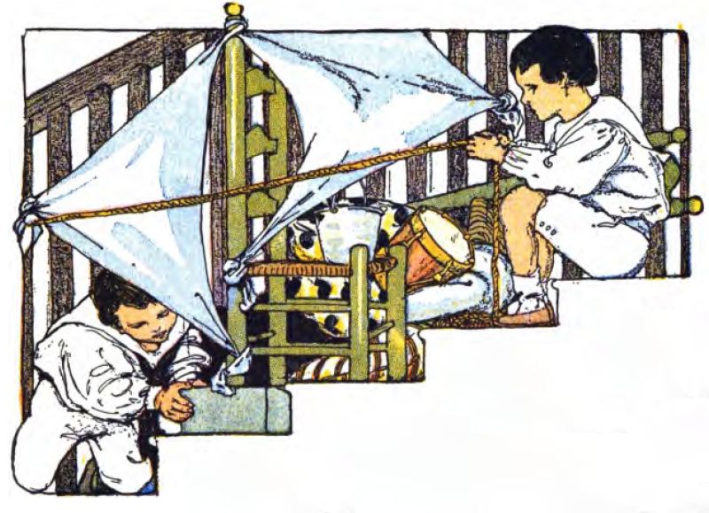Two children sit on a staircase, turning household items into a sailing ship. They use two white blankets for sails, tying them to the balusters and a chair post. A toy drum sits next to an overturned chair. The child on the right, with dark hair, sits higher and holds a thick brown rope, pretending to steer. He wears a white long-sleeved shirt and matching shorts. The child on the left sits lower, peeking out from under a sail. He holds a gray box or block. He also wears a white outfit with a dark sailor-style collar.