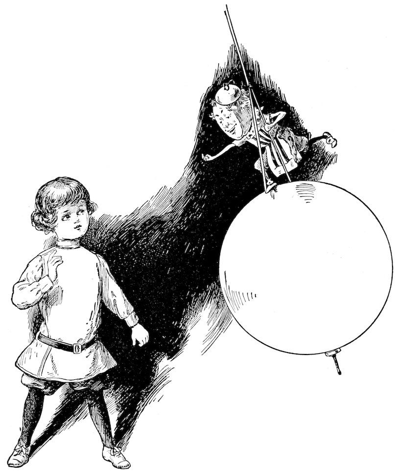 A young boy looking at a large toy balloon with a small figure attached to it.