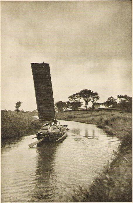 I watch the rice boats pass along the canal.