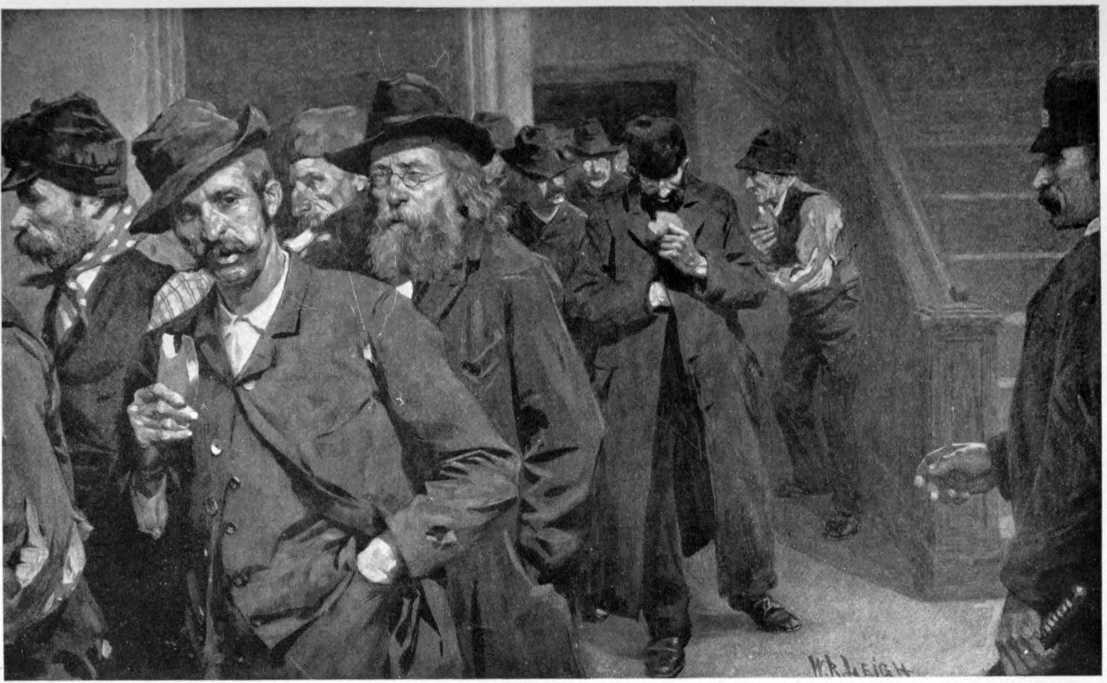 A line of men in worn out clothes exiting through a door watched
by a policeman. Many of them are eating bread.