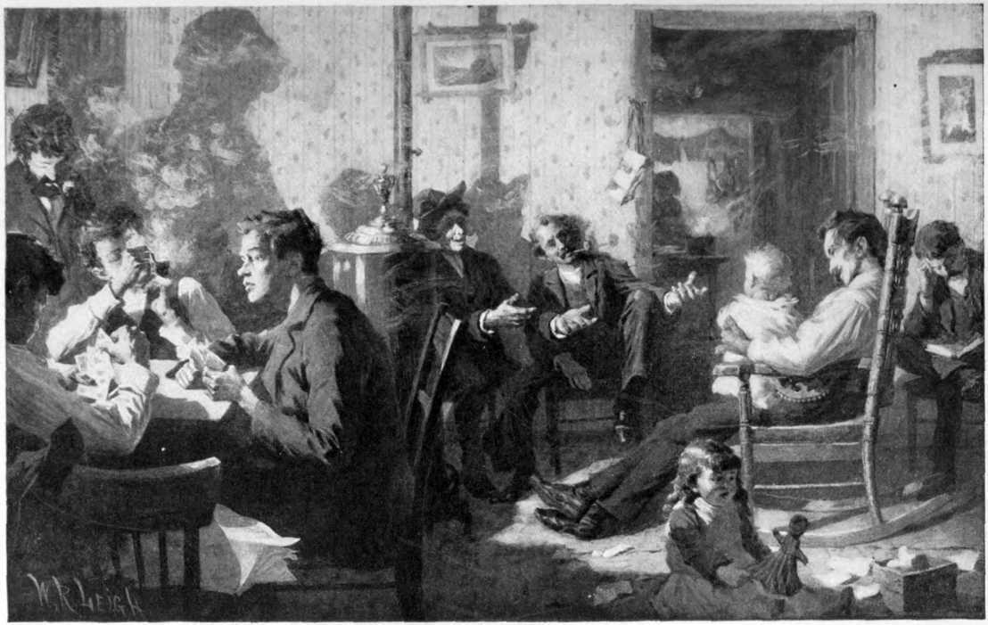 A room full of mostly men chatting.
One man is sitting in a rocking chair holding a toddler.