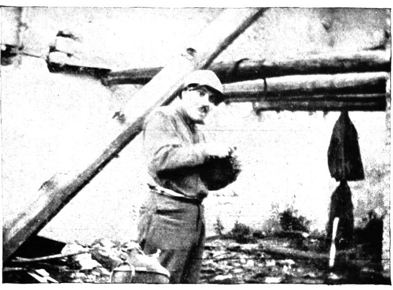 A man in unform eating while standing upright.