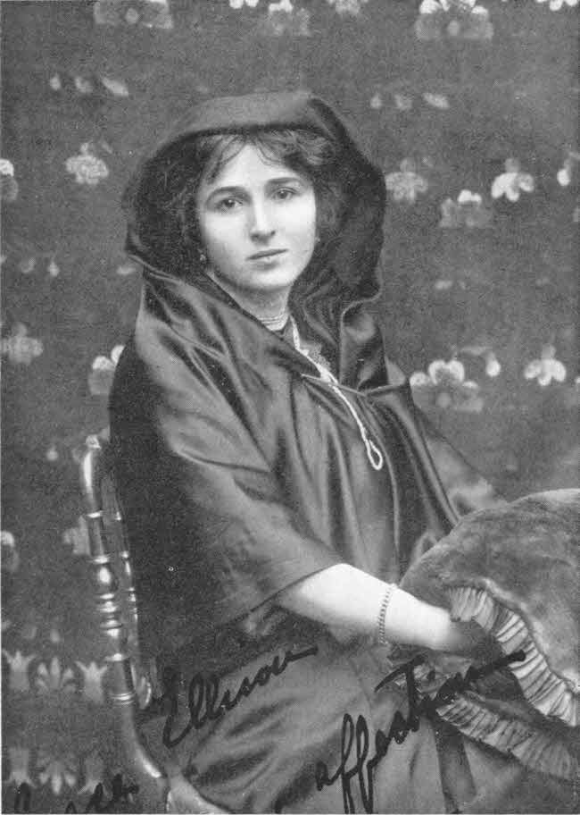 This photo shows the upper body of
a seated young woman. Her body and much of her hair are covered by a flowing
robe-like garment with her lower arms uncovered, and her hands under a
blanket-like covering. There is a short inscription in English script.